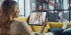 Mulher em consulta online com médica, representando a cobertura de telemedicina oferecida pelo seguro de vida.