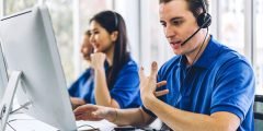 Central de atendimento com profissionais uniformizados prestando suporte técnico por telefone, representando o serviço emergencial 24h do seguro residencial.