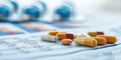 Cápsulas e comprimidos sobre relatório médico, simbolizando a cobertura seguro viagem para despesas farmacêuticas durante o tratamento em viagem.