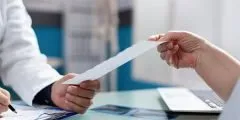 Entrega de laudo médico em consultório, simbolizando o reembolso de despesas médicas incluído no seguro de vida.