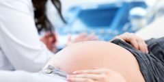 Grávida sendo examinada por profissional da saúde, simbolizando a cobertura hospitalar com obstetrícia, essencial para gestantes no plano de saúde empresarial.