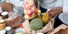 Distribuição de alimentos como frutas, verduras e itens de primeira necessidade, simbolizando os benefícios sociais oferecidos por empresas por meio do Seguro de Vida Empresarial, como cestas básicas ou auxílio-alimentação.